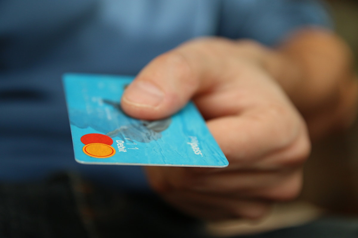close-up of a hand holding a blue debit card