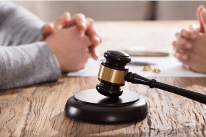 gavel placed on a table with two people seated in the background