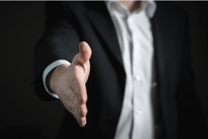 a man extending his hand for a handshake in a business suit